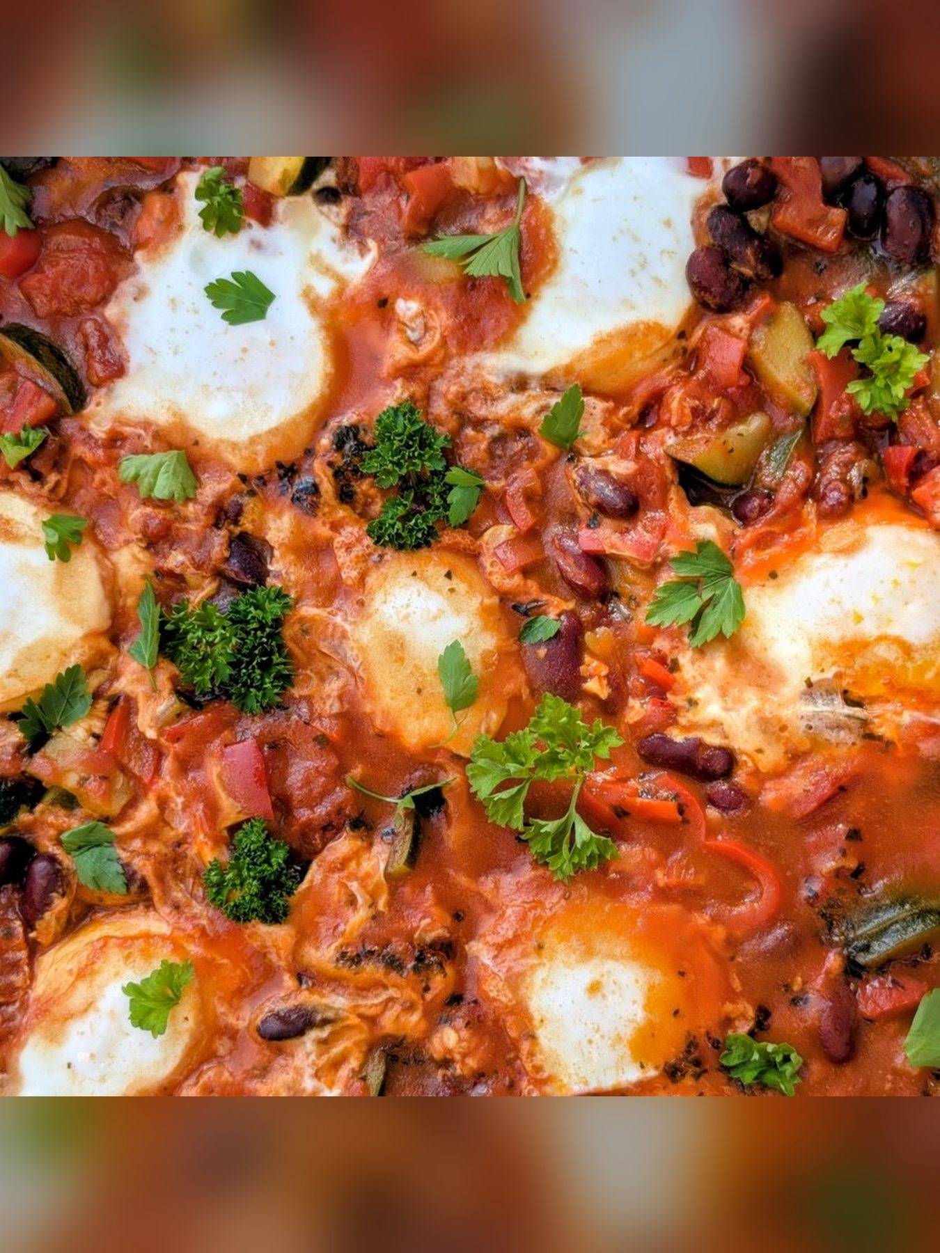 Drei grüne Knödel auf Gemüse in Tomatensauce